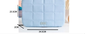 Detailed dimensions of the light blue quilted laptop sleeve with brand logo and measurements