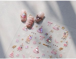 Detail of Christmas nail stickers with pink bears, reindeer, and gold glitter patterns