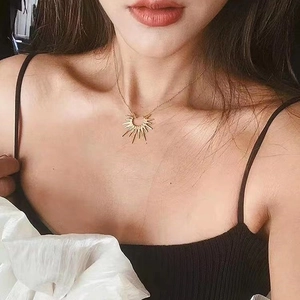 Elegant gold sunburst pendant necklace in titanium steel for women on model