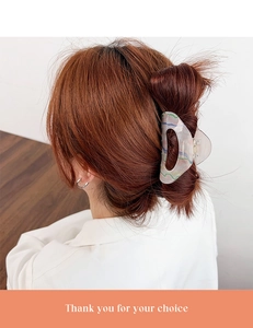 Detail of oil painting style acrylic hair claw clip with marble texture on model