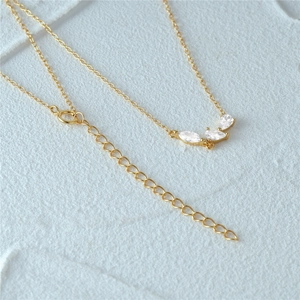 Macro detail of gold necklace featuring cluster marquise zircon pendant and O-chain links