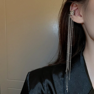 Detail of silver long chain fringe ear cuff earring worn on model for a stylish look