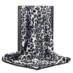 Detail of premium leopard print satin silk scarf with elegant glossy finish and sharp texture