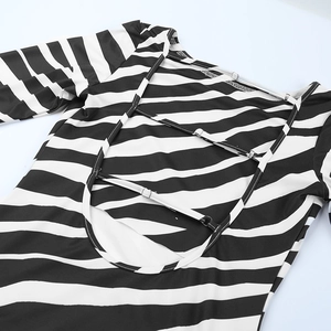 Detail of backless striped dress featuring three adjustable straps and open back cutout