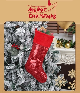 Close-up of red sequined Christmas stocking hanging by fireplace with festive decor
