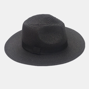 Detail of a black woven straw Panama hat featuring a matching satin ribbon and bow