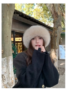 Close-up of fluffy beige faux fur bucket hat for winter warmth in outdoor street style