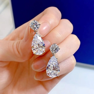 Close-up of a pair of silver teardrop drop earrings with sparkling cubic zirconia stones