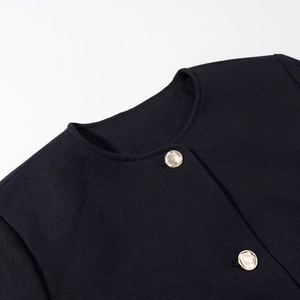 Detail of round neckline on twill jacket featuring elegant round gold metal buttons