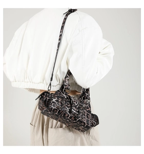 Chic leopard print crossbody bag with multiple buckles and straps styled on a model