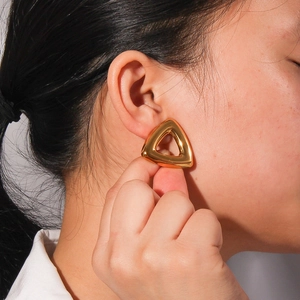 Modern 18K gold-plated stainless steel hollow triangle stud earrings worn on ear
