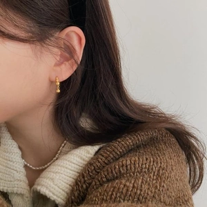 Elegant gold bead earrings on a female model with a minimalist aesthetic style