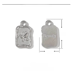 Detail of a stainless steel rectangular butterfly charm with Beauty engraving and dimensions