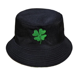 Dettaglio del ricamo a quadrifoglio verde su un cappello a secchiello in tela nera di qualità