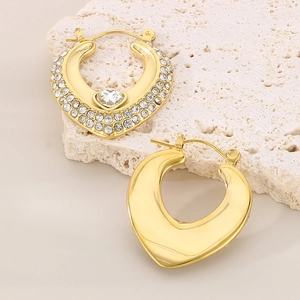 Gros plan de boucles d'oreilles cœur dorées avec incrustation de zircone blanc