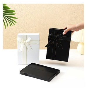 Detailed view of collapsible black and white gift boxes with elegant ribbon bows