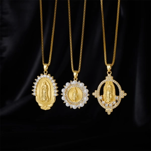 Three gold Virgin Mary pendant necklaces with white zircon inlays on black silk fabric