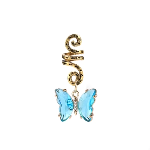 Détail de la manchette de cheveux dorée avec pendentif papillon en verre bleu facetté