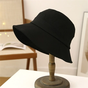 Detail of black cotton bucket hat texture with horizontal stitching on wooden stand