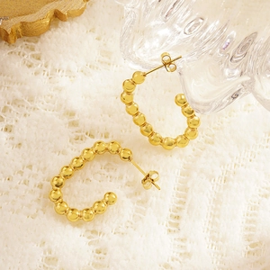 Chic gold beaded G-shaped hoop earrings made of titanium steel on white lace fabric