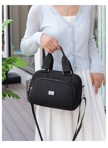 Nylon crossbody bag shown on a model with light blue cardigan and white pleated skirt