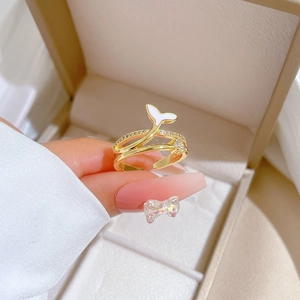 Adjustable gold mermaid tail ring with white enamel and zircon stones in a jewelry box