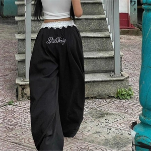 Vue détaillée du pantalon large noir avec taille en dentelle blanche et broderie Girl Baby