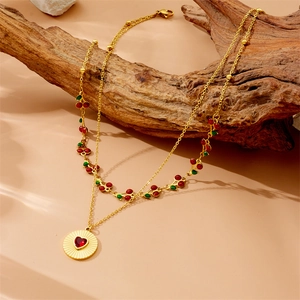 Double-layered gold necklace featuring cherry charms and a red heart gemstone pendant