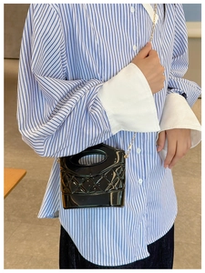 Dettaglio della mini borsa a secchiello trapuntata nera con catena su modella