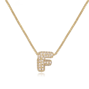 Close-up of gold plated box chain necklace with iced out bubble letter F pendant