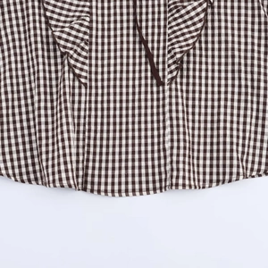 Brown gingham shirt featuring ruffled hem and delicate tie details in a minimalist style