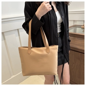 Professional shot of model carrying a khaki nylon tote bag with leather straps for daily use