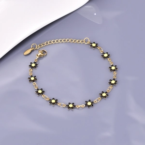 Détail du bracelet chaîne marguerite dorée avec fleurs en émail et fermoir mousqueton sûr