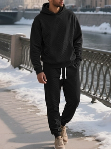 Close-up of black men's tracksuit featuring unique diamond knit texture and ribbed cuffs