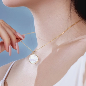 Detail of s925 silver gold necklace with round mother of pearl shell pendant on model