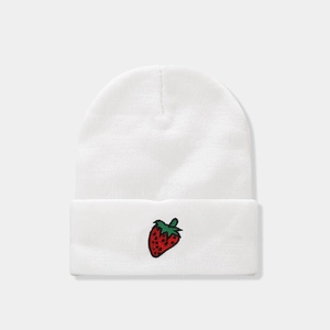 Close-up of white knitted beanie with detailed red strawberry embroidery on the fold