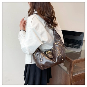 Detail der dunkelbraunen Vintage Hobo-Tasche mit goldenen Nieten und Quasten-Reißverschluss