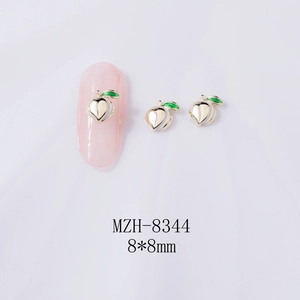 Detail view of 8x8mm alloy peach nail charms with green leaves on pink manicure