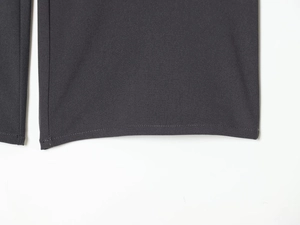 Detail of the hem stitching and dark gray twill fabric on women's trousers