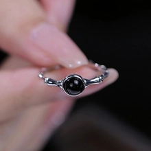 Dettaglio di un anello in argento S925 con pietra nera rotonda e fascia in stile bambù