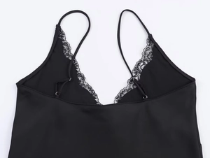 Detail of black satin camisole with delicate lace trim and adjustable spaghetti straps