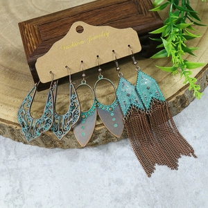 Detailed view of bohemian turquoise drop earrings with vintage bronze tassels on wood