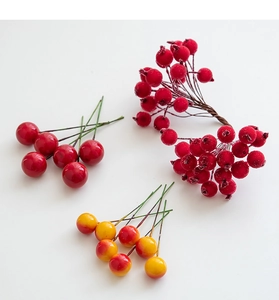 Detail of assorted red artificial berries with glossy and frosted textures for DIY crafts