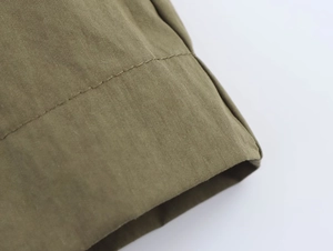 Close-up of military green cotton blend fabric showing reinforced double stitching detail
