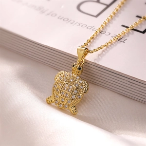 Macro shot of gold-plated sea turtle pendant with inlaid zircons on a delicate chain