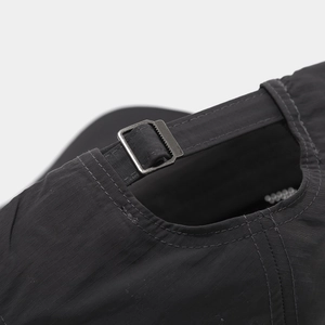 Detail of black quick-dry nylon baseball cap featuring a metal buckle adjustment strap