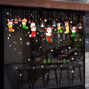 Close-up of festive Christmas window stickers featuring Santa, reindeer, and snowy graphics