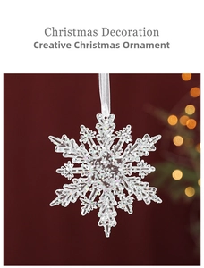 Macro shot of transparent acrylic snowflake ornament with silver glitter and ribbon