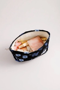 Spacious black velvet makeup bag with blue daisy embroidery and metal zipper detail