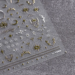 Macro shot of gold and silver embossed moon and star patterns on fancy nail art stickers